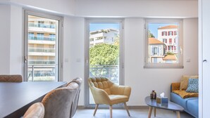 Ein modernes Wohnzimmer mit einer Couch, einem Sessel und einem Esstisch.