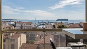 A balcony with a view of a marina and cityscape. - Admire Panoramic Ocean Views Thru Walls of Windows (Cannes)