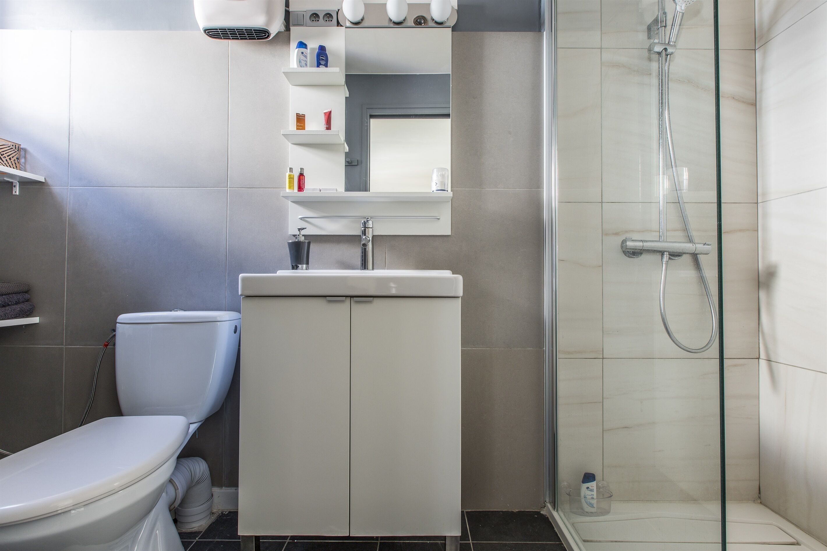 A bathroom with a toilet, sink, and shower.