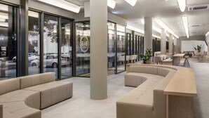A modern lobby with a curved seating area, large windows, and a reception desk. - B&B Hotel Lisboa Oeiras  (Oeiras)