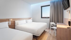 A hotel room with two beds, a desk, a chair, and a TV mounted on the wall. - B&B Hotel Lisboa Oeiras  (Oeiras)