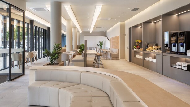 A modern interior with a curved seating area, a coffee station, and a reception desk. - B&B Hotel Lisboa Oeiras  (Oeiras)