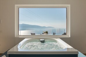 Ein Whirlpool mit Blick auf ein Gewässer und Berge.