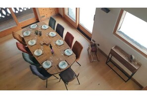 Een eetgedeelte met een houten tafel voor zes personen, omringd door stoelen.