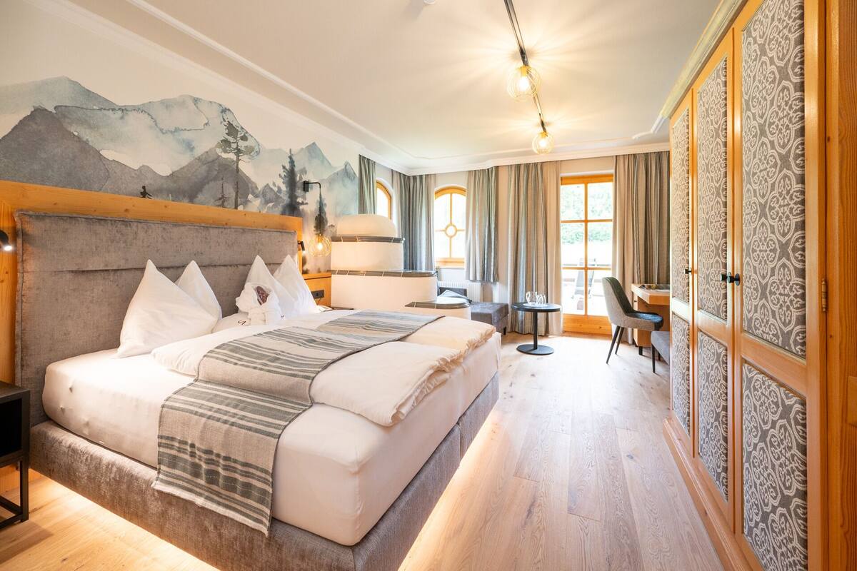 A spacious bedroom with a large bed, a desk, and a chair.