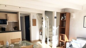 A modern apartment with a kitchen, dining area, living room, and staircase. - GARENNE - Holiday apartment for rent in Carnac - T23 (Carnac)