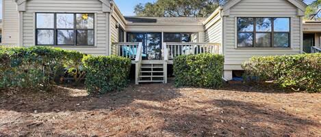 A two-story house with a front deck and a covered entryway.