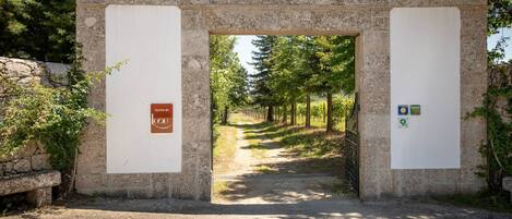 Un arco de piedra con un letrero que dice "Olivet de Luou" y un símbolo de reciclaje.