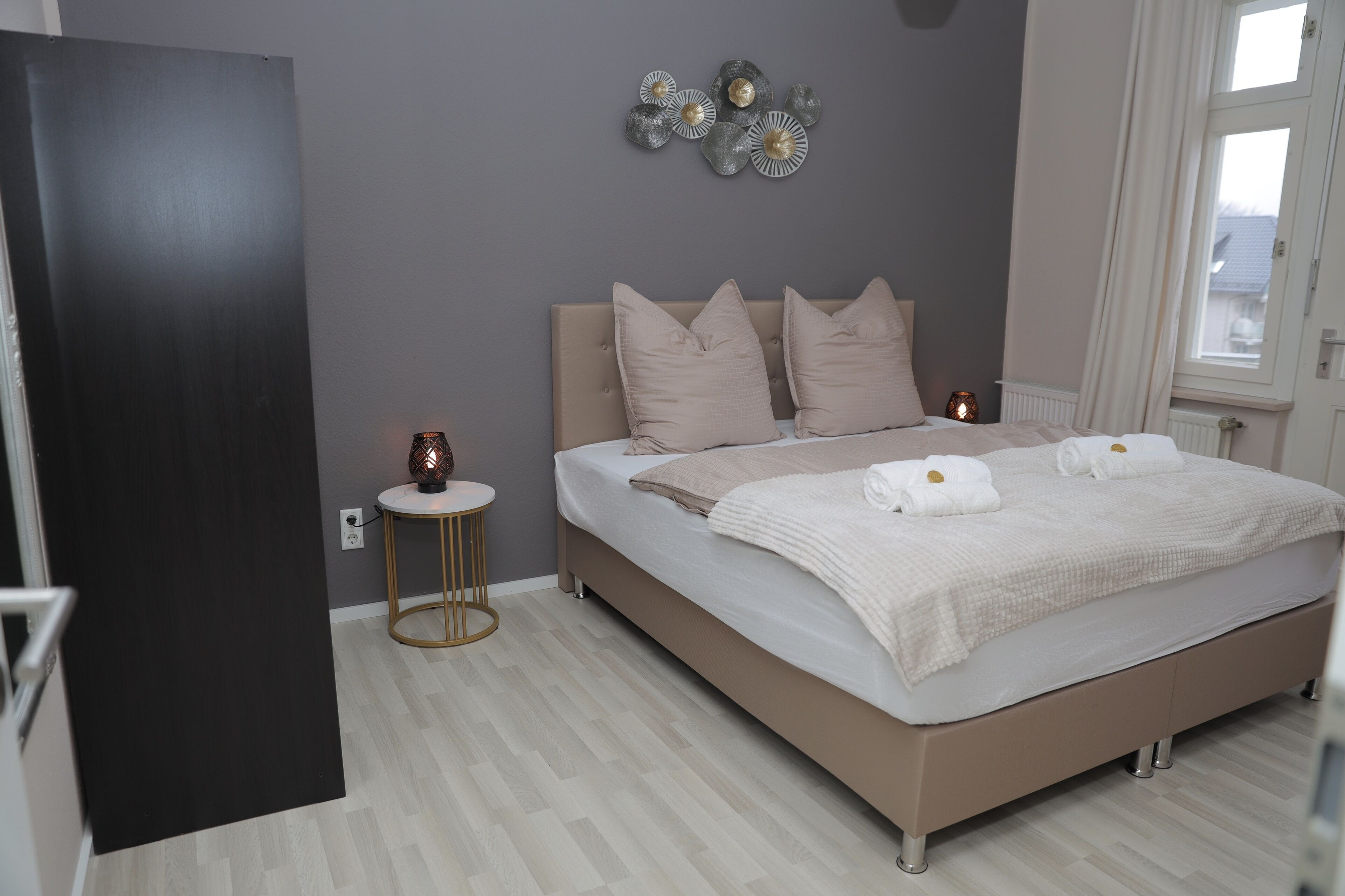 Une chambre à coucher comprenant un lit, une table de chevet et des éléments décoratifs sur les murs.