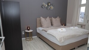 A bedroom with a bed, bedside table, and decorative wall art.