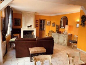 Un salon avec un canapé marron, une petite table et une cheminée.