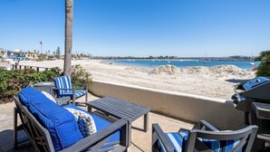 Une terrasse avec mobilier d’extérieur donnant sur une plage.