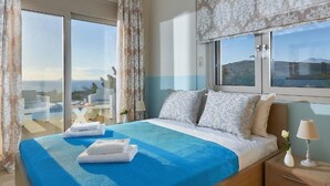 Ein Schlafzimmer mit einem großen Bett, Meerblick und einem Balkon.