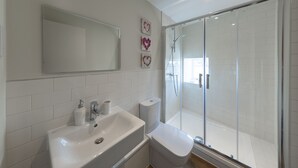 Ein Badezimmer mit Waschbecken, Toilette und Duschkabine.