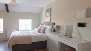 Ein Schlafzimmer mit Bett, Nachttisch, Schreibtisch und Stuhl.