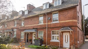 A red brick terraced house with a front garden, a door marked '15', and a satellite dish. - HEREFORD CITY – St Owens Terrace: Spacious 3-Storey Home, Walk to Centre (Hereford)