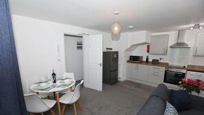 Un espace de vie compact comprenant un coin repas, une kitchenette et un canapé.