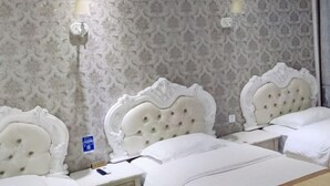 A hotel room with three beds, each with a white headboard and white bedding. There are two wall-mounted light fixtures. - Chuxiong Fuxing Hotel (Chuxiong City)
