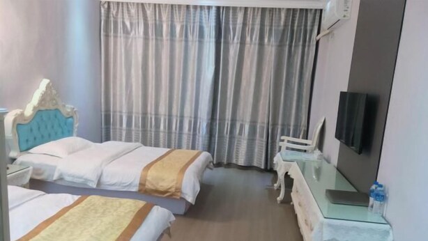 A hotel room with two beds, a TV, a dresser, and a window with curtains. - Chuxiong Fuxing Hotel (Chuxiong City)