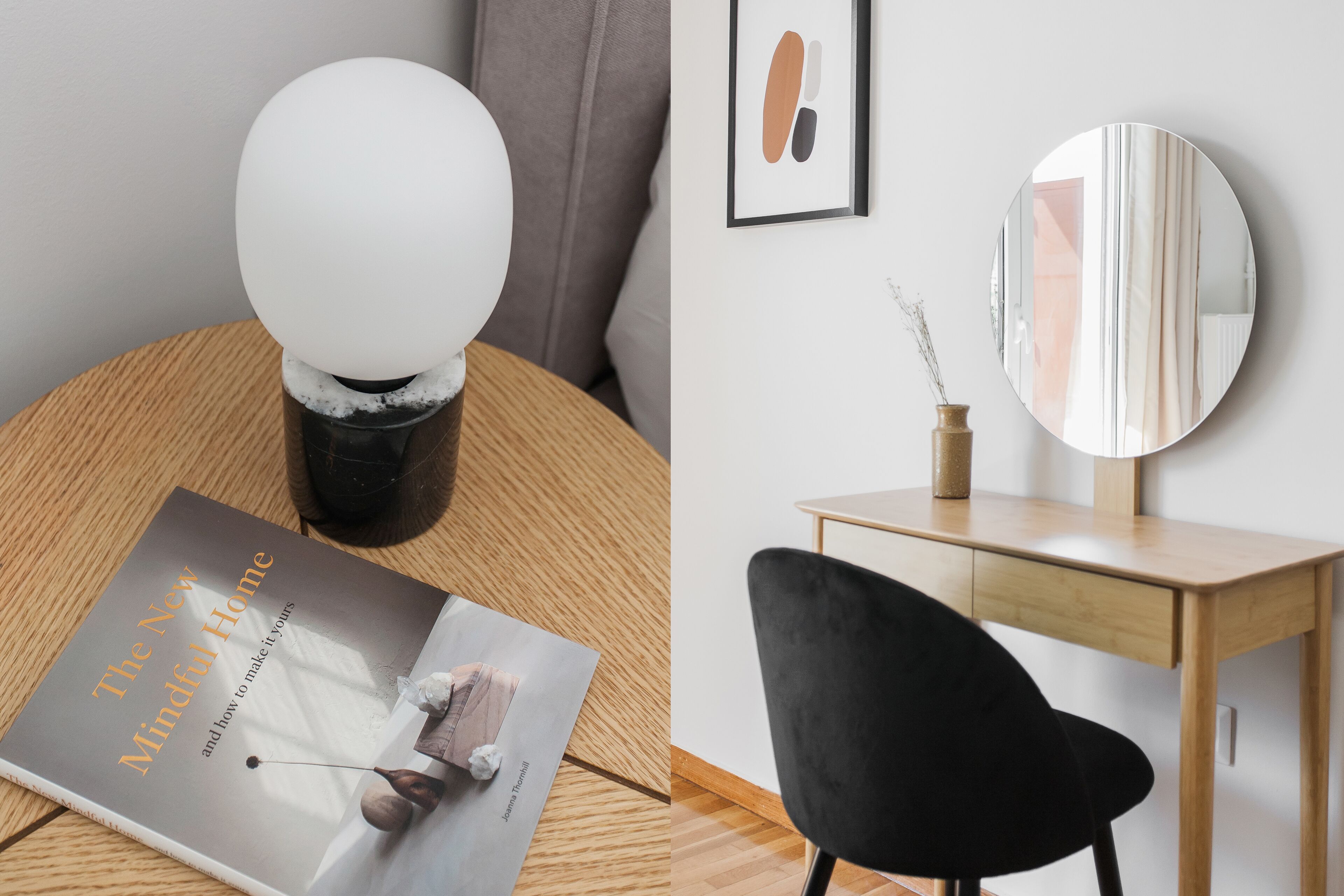A modern room with a round table, a black chair, a wooden desk, and a round mirror on the wall.