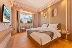 Hotelkamer met een groot bed, een televisie, een balkon met uitzicht en een tafeltje.