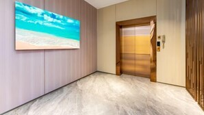 Um elevador moderno com acabamento em madeira e painel digital.