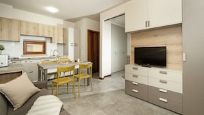 A modern kitchen with a dining area, a TV, and a sofa. - Lauri 0/18 by Wonderful Italy (Desenzano del Garda)