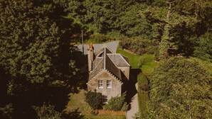 An isolated stone house surrounded by dense forest.