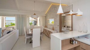 Ett modernt hotellrum med en matplats, ett vardagsrum och utsikt över omgivningarna.
