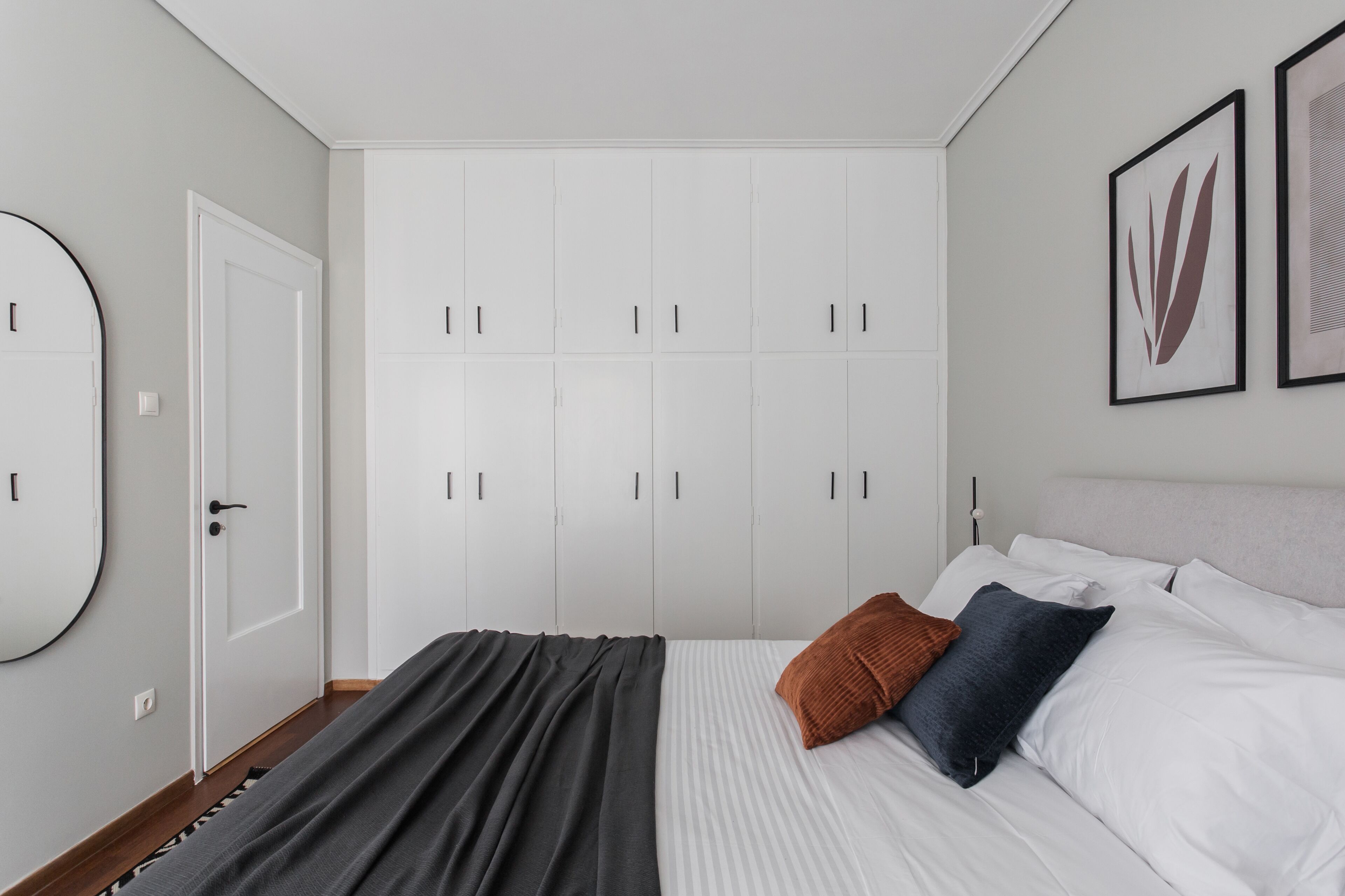Une chambre à coucher avec un lit, une armoire et un miroir.