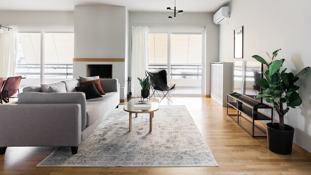 A modern living room with a grey sofa, a coffee table, and a potted plant. - Celestial 3BR Apartment with Balcony (Palaio Faliro)