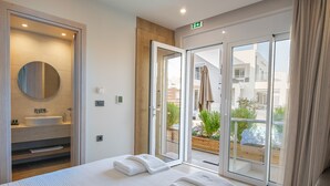 Una moderna camera d'hotel con un letto grande, uno specchio rotondo, un lavandino e un balcone con vista sulla città.