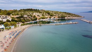 Una zona costiera con spiaggia, barche e un molo.
