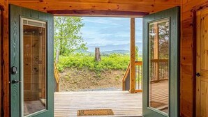 En træhytte med en glasdør, der fører ud til en terrasse.