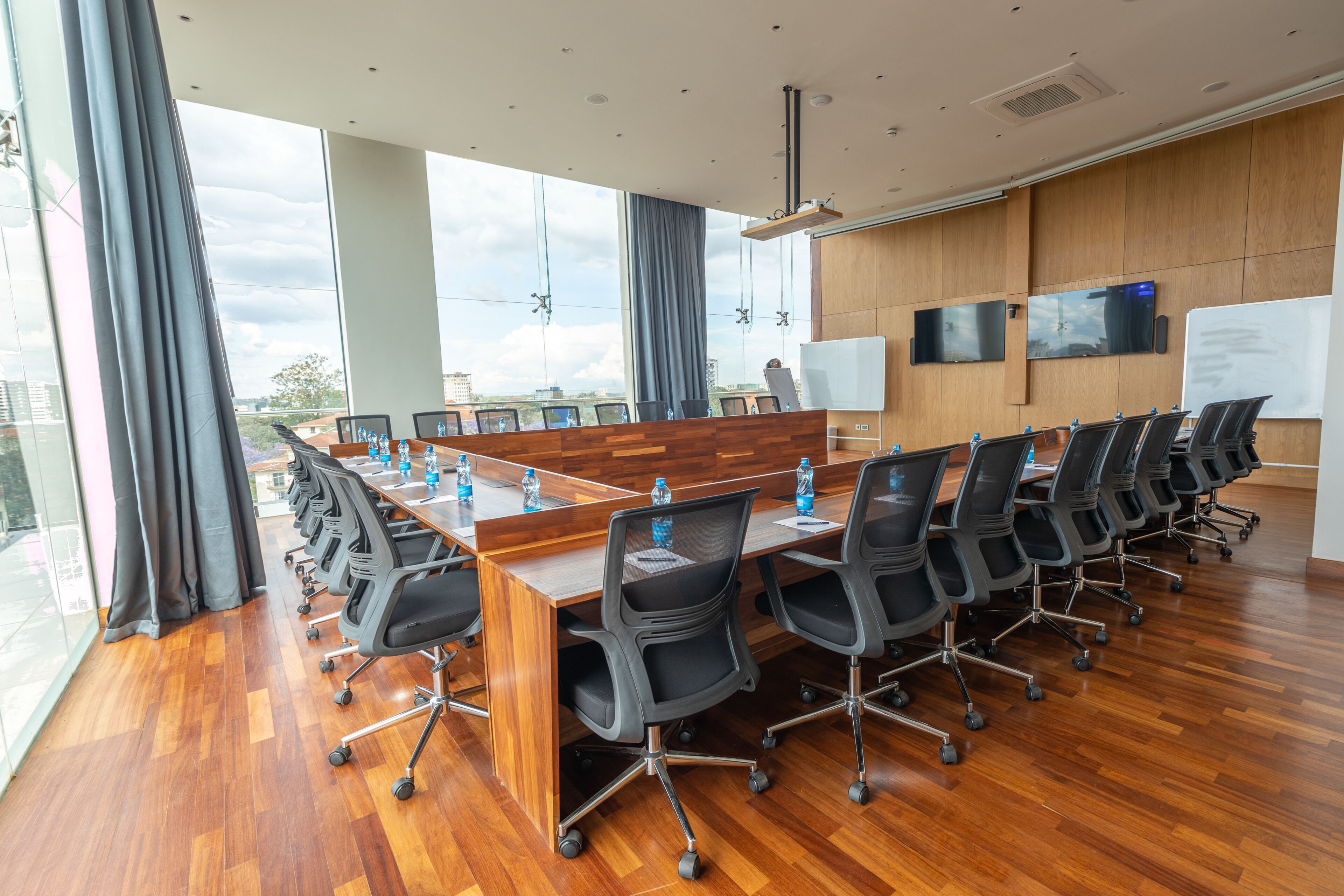 A conference room with a long table, black chairs, and a whiteboard.