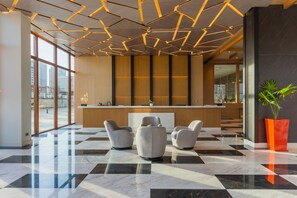 A modern lobby with a check-in counter, seating area, and large windows. - Broadwalk Residency (Nairobi)