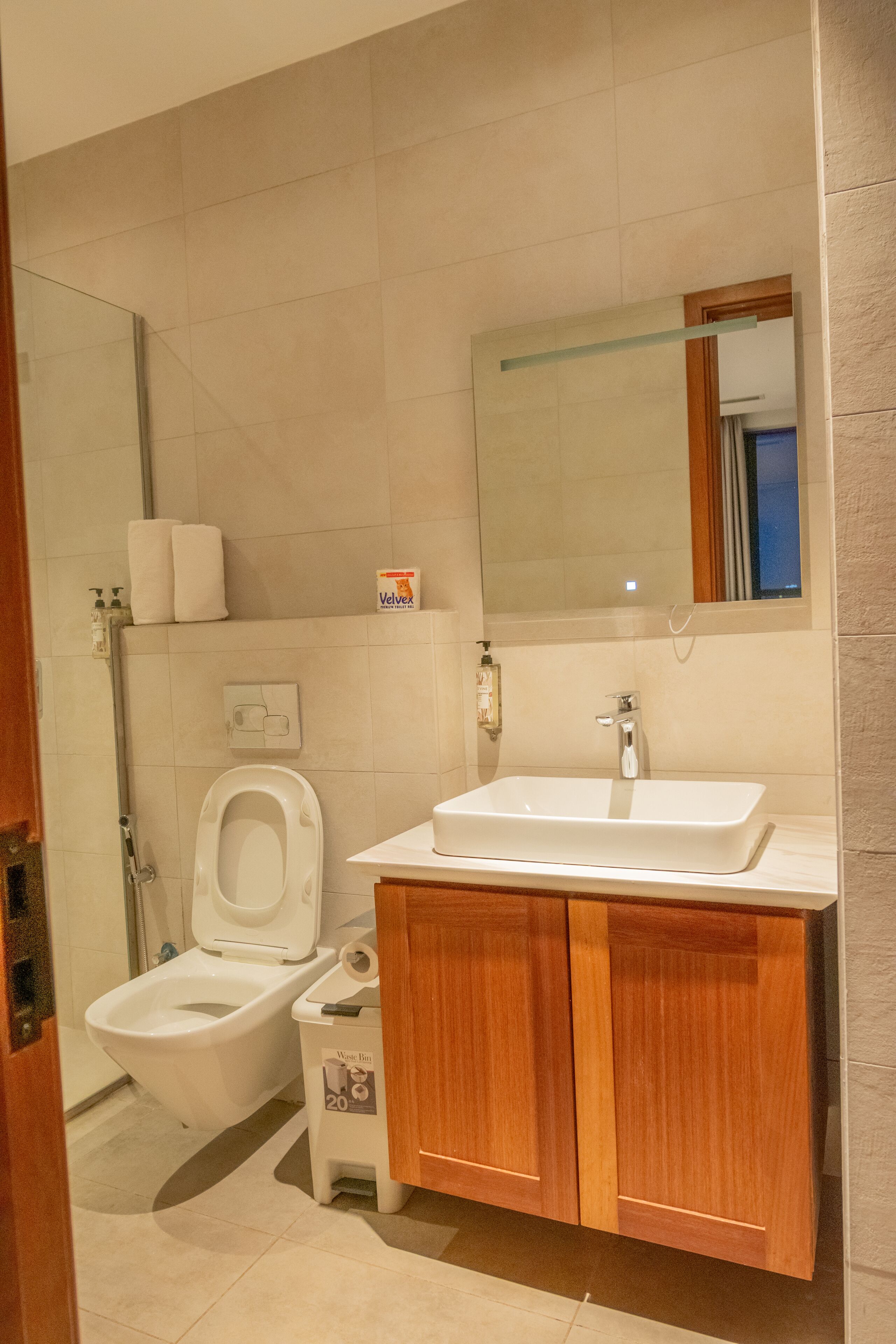 Une salle de bain avec des toilettes, un lavabo et un miroir.