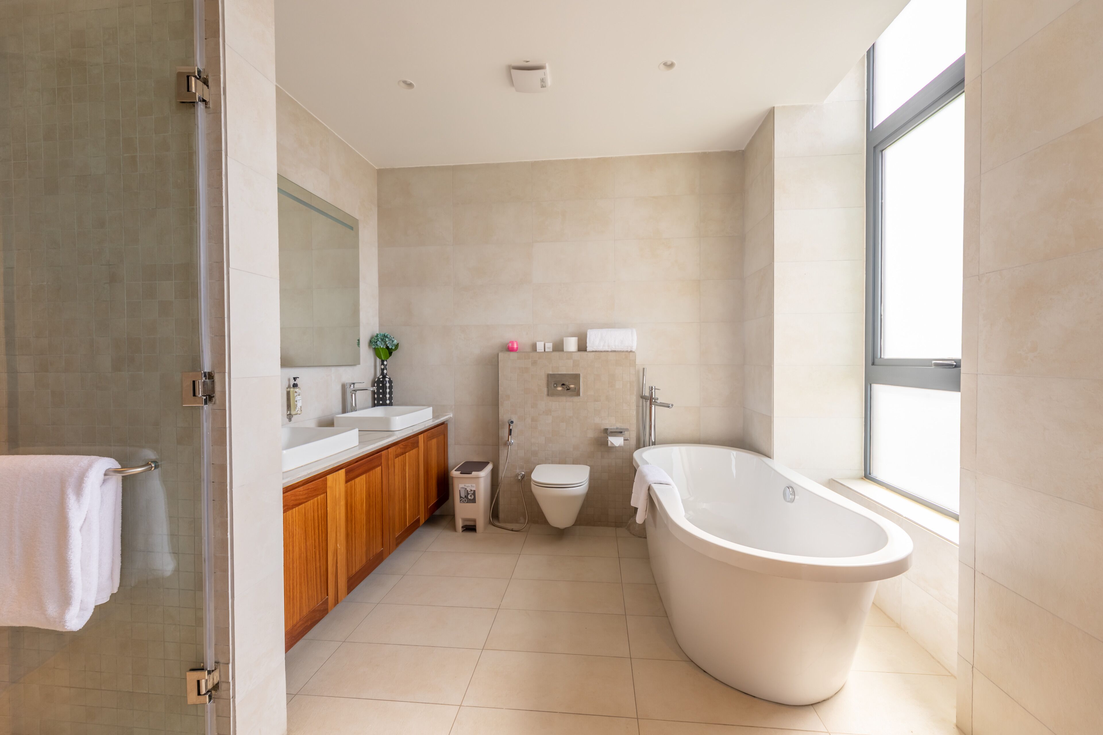 Une salle de bain moderne avec une baignoire sur pieds, des toilettes et un meuble-lavabo avec un miroir et un évier.