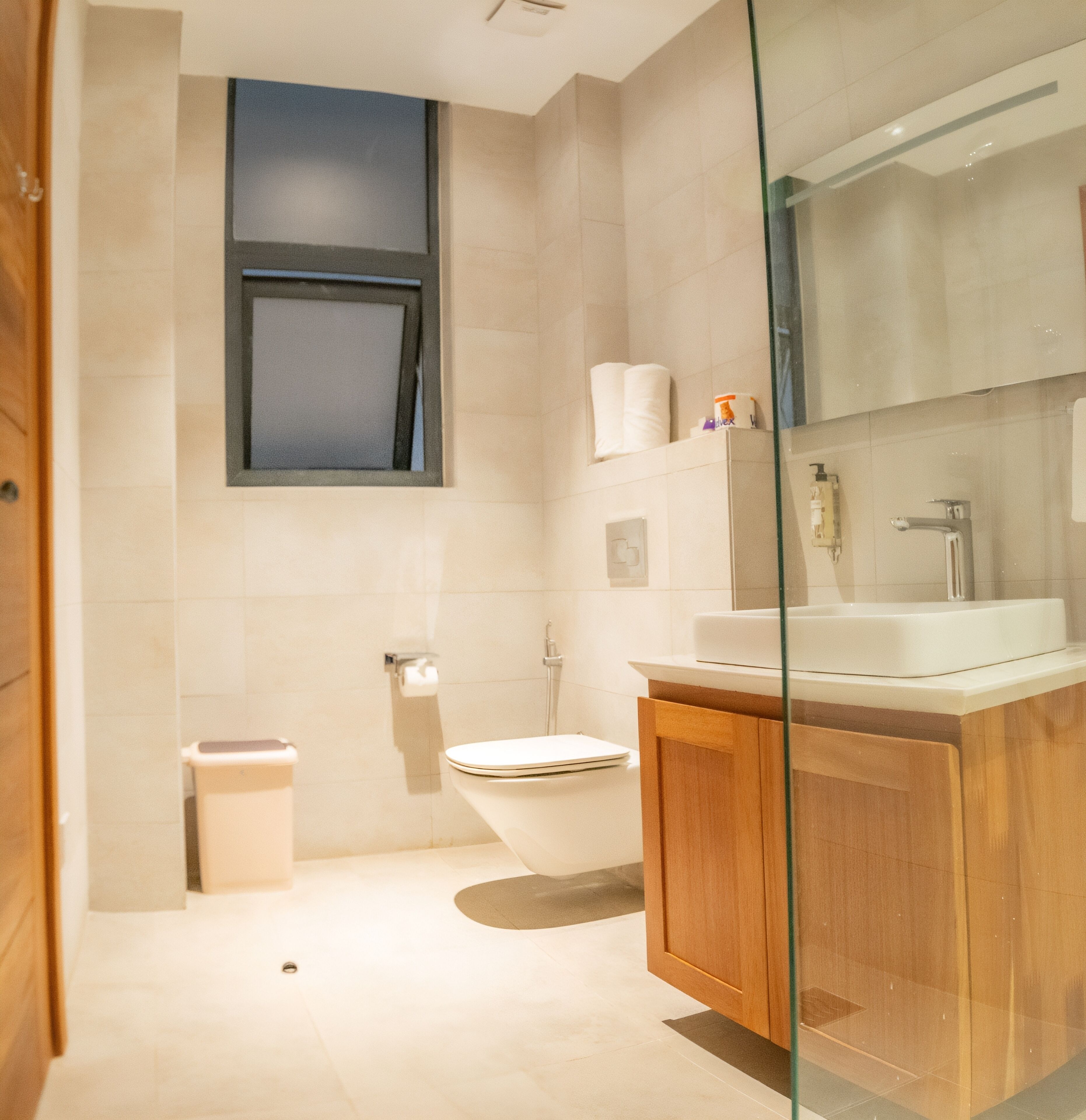 Un baño moderno con inodoro, lavamanos y cabina de ducha de vidrio.