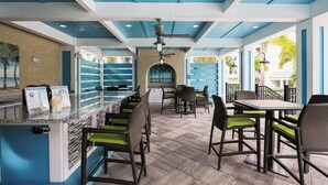 A restaurant with outdoor seating, blue and white decor, and a ceiling fan. - Turquoise Turtle One Particular Harbour 388-403 · Sound Views · 14-Night Min (Bradenton)