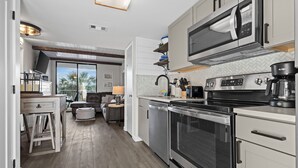 Una cocina moderna con electrodomésticos de acero inoxidable, un comedor con vistas y una zona de estar acogedora.