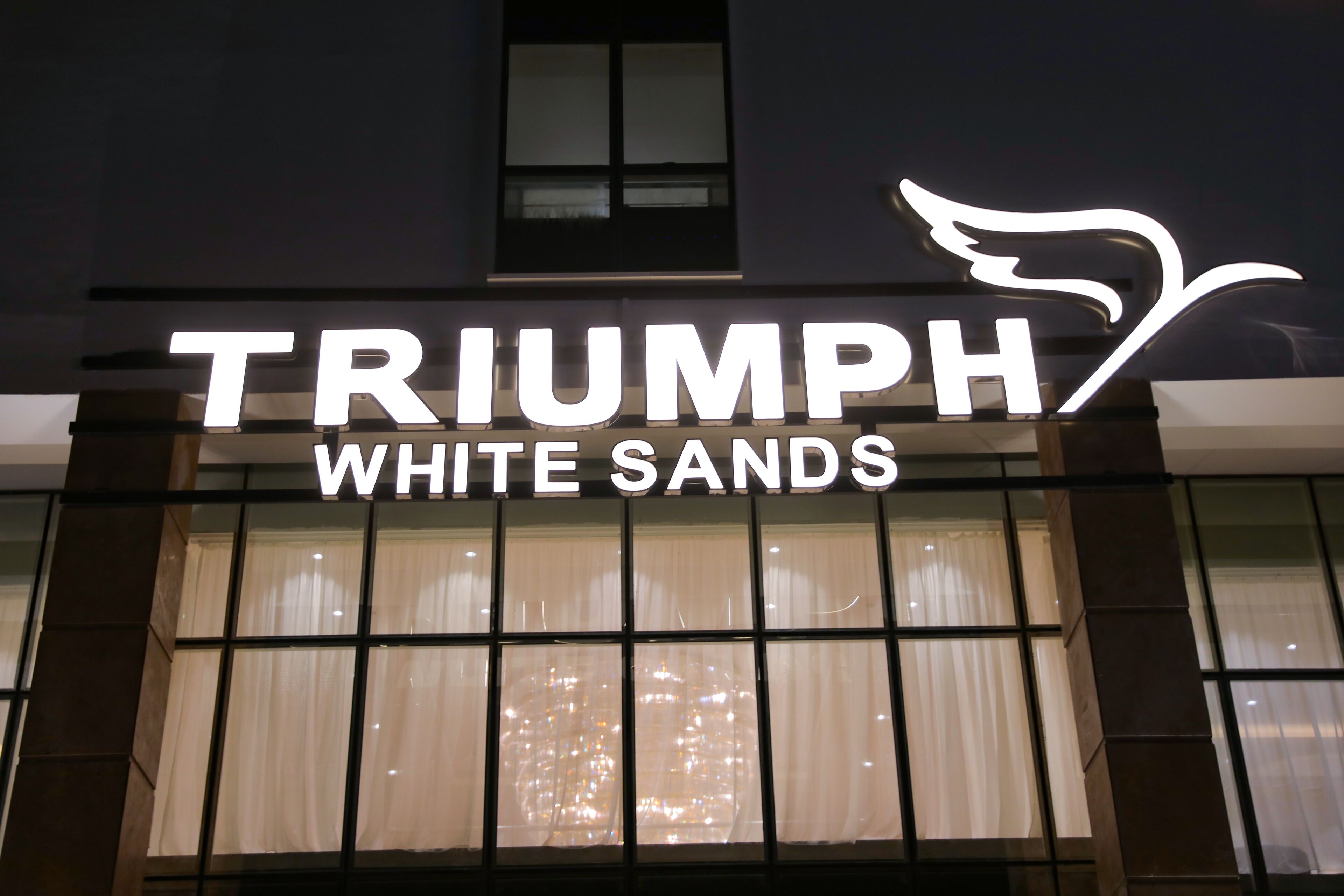 Un letrero de hotel con el nombre 'TRIUMPH WHITE SANDS'.