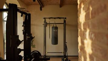 A gym with a squat rack, a bench press, and a punching bag.