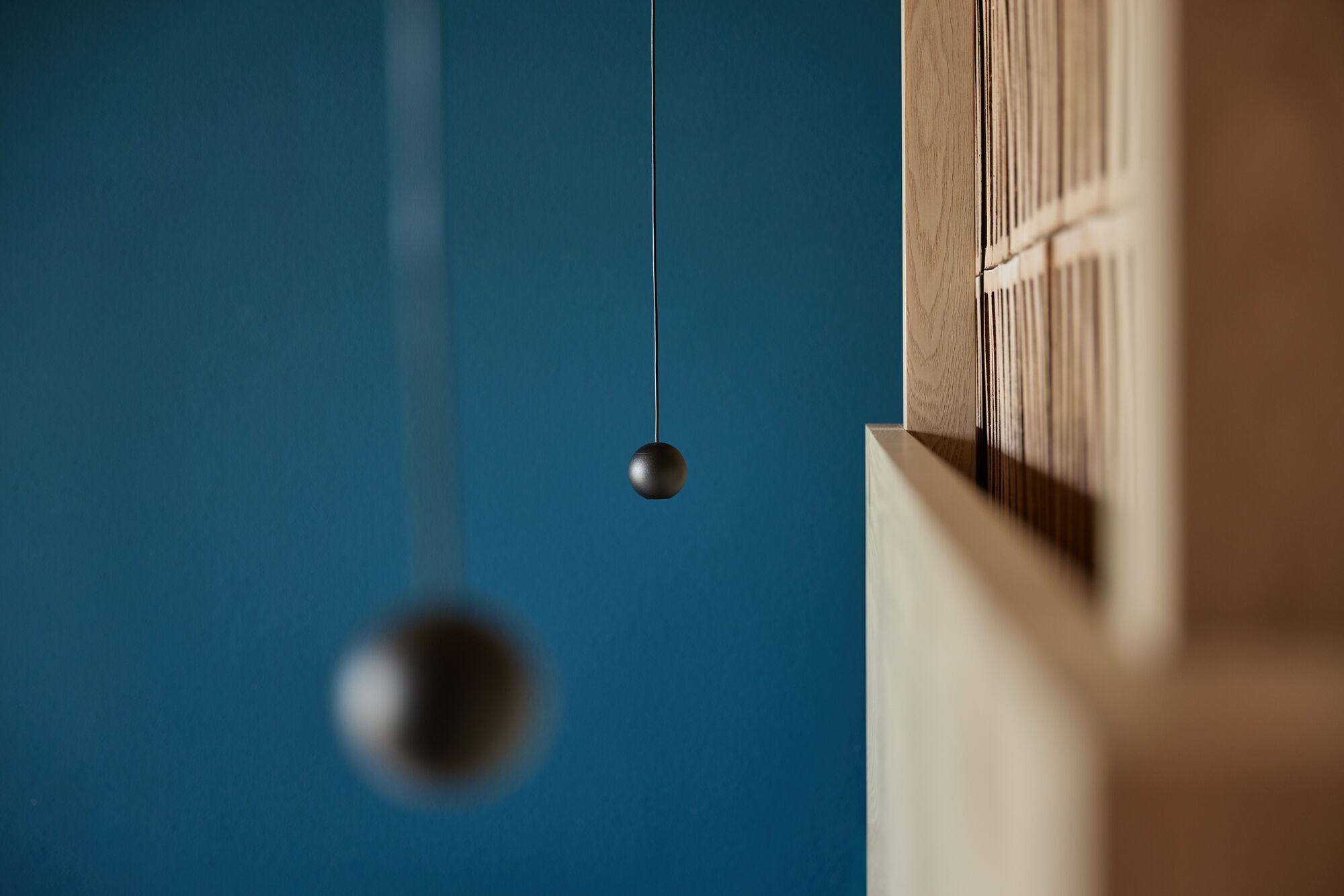 A close-up of a wooden structure with a hanging spherical object.