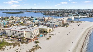Ein Hotel an der Küste mit mehreren Etagen, einem Schwimmbad und Blick auf den Strand.