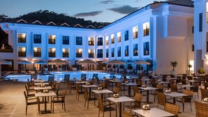 A hotel with a swimming pool, outdoor seating with umbrellas, and a large building with multiple windows. - Saint Star Kemer (Kemer)