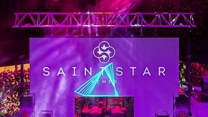 Un palco con il testo 'SAINTSTAR' e un'attrezzatura per DJ.