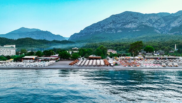 A coastal resort with beachside seating, a marina, and mountainous backdrop. - Saint Star Kemer (Kemer)