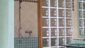 A bathroom with a glass shower enclosure, tiled walls, and a visible showerhead. - Gîte le plane tree (Aubignan)