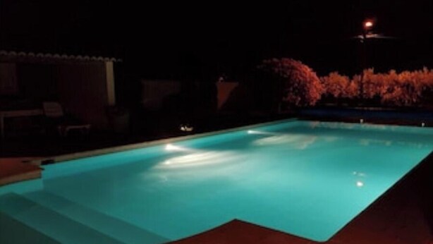 A swimming pool at night with steps leading into it. - Gîte le plane tree (Aubignan)
